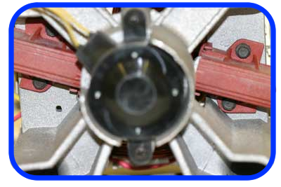 A view of the rear of the washing machine motor showing the carbon brushes fitted