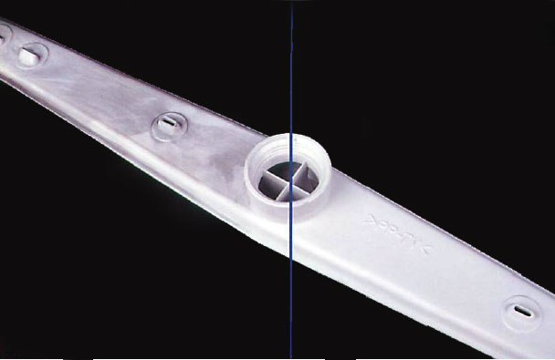 Plastic items in a dishwasher, a spray arm here, with black marks or mildew