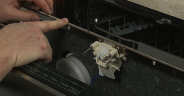 Showing the dishwasher door lock behind the front facia of a dishwasher
