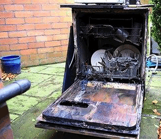A burnt out dishwasher after a fire