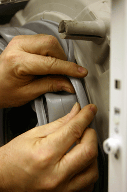 refitting the new door seal to the washing machine