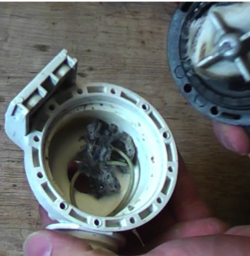 A washing machine pump blocked by junk in it
