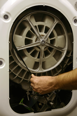 A washing machine belt being fitted correctly