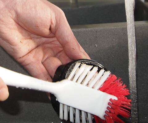 Scrubbing the feed guard with a washing up brush