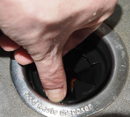 Putting the rubber feed guard back into place after cleaning the disposal